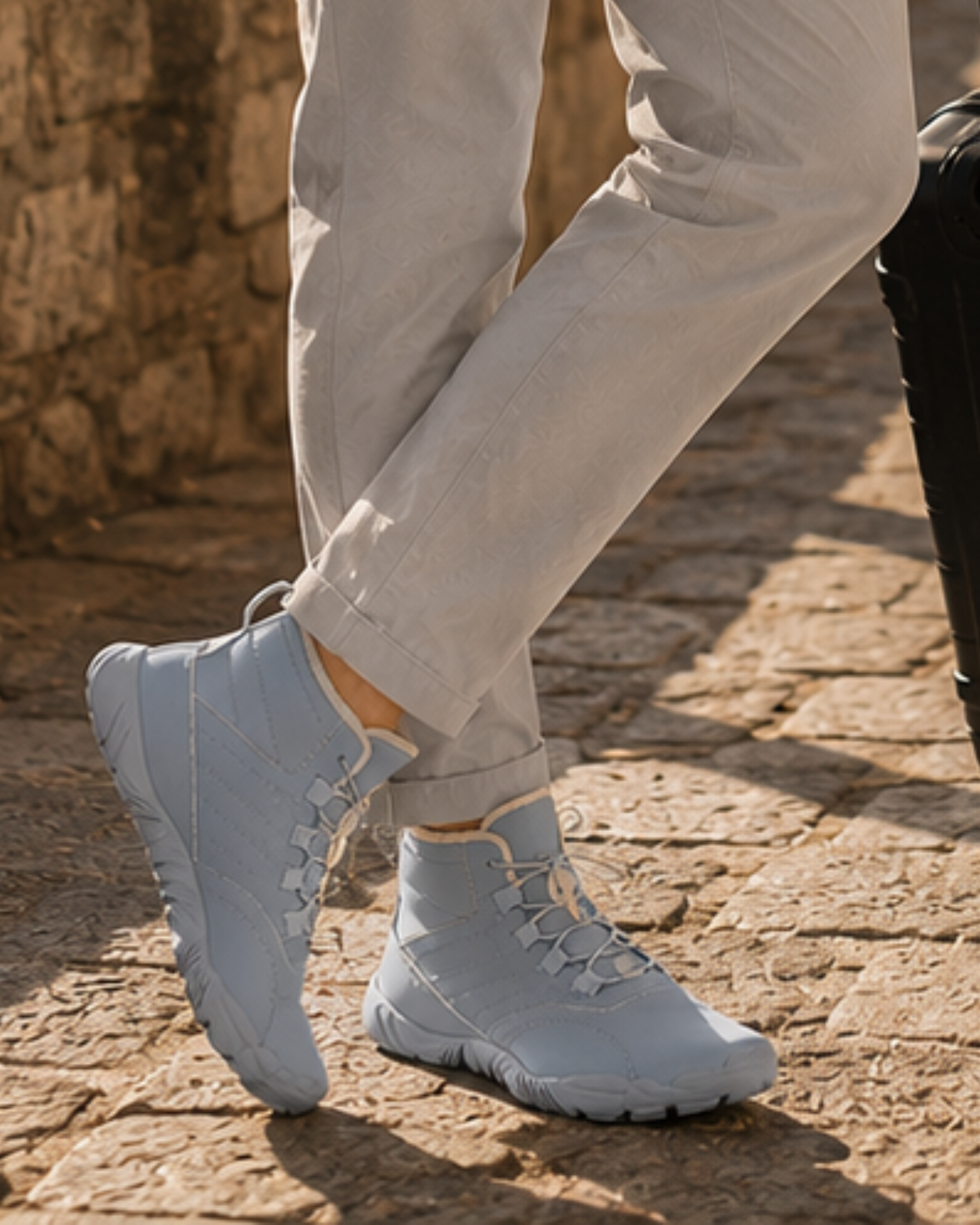 Person wearing light gray sneakers on a stone pavement