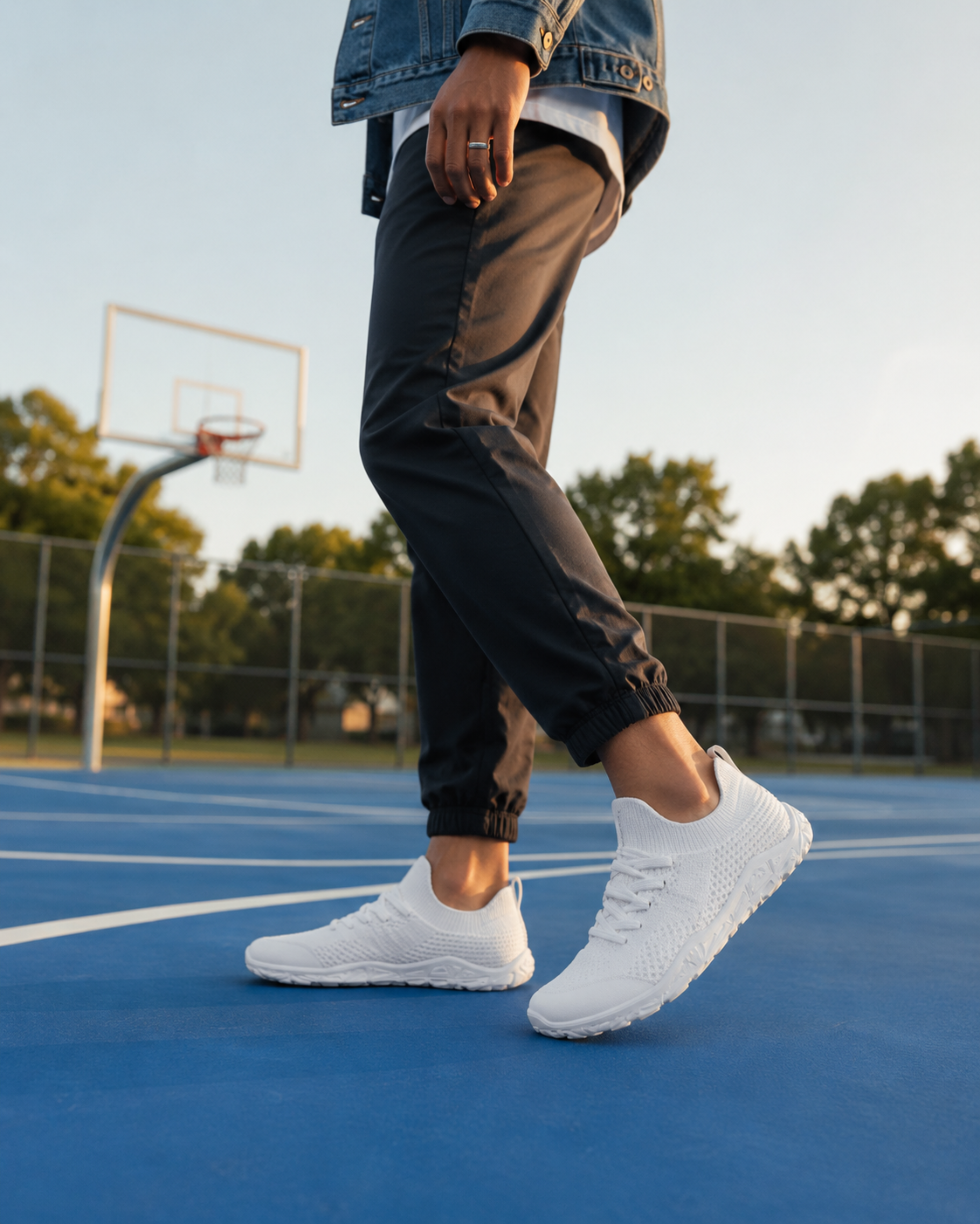 Person wearing white sneakers on a basketball court with a blurred background